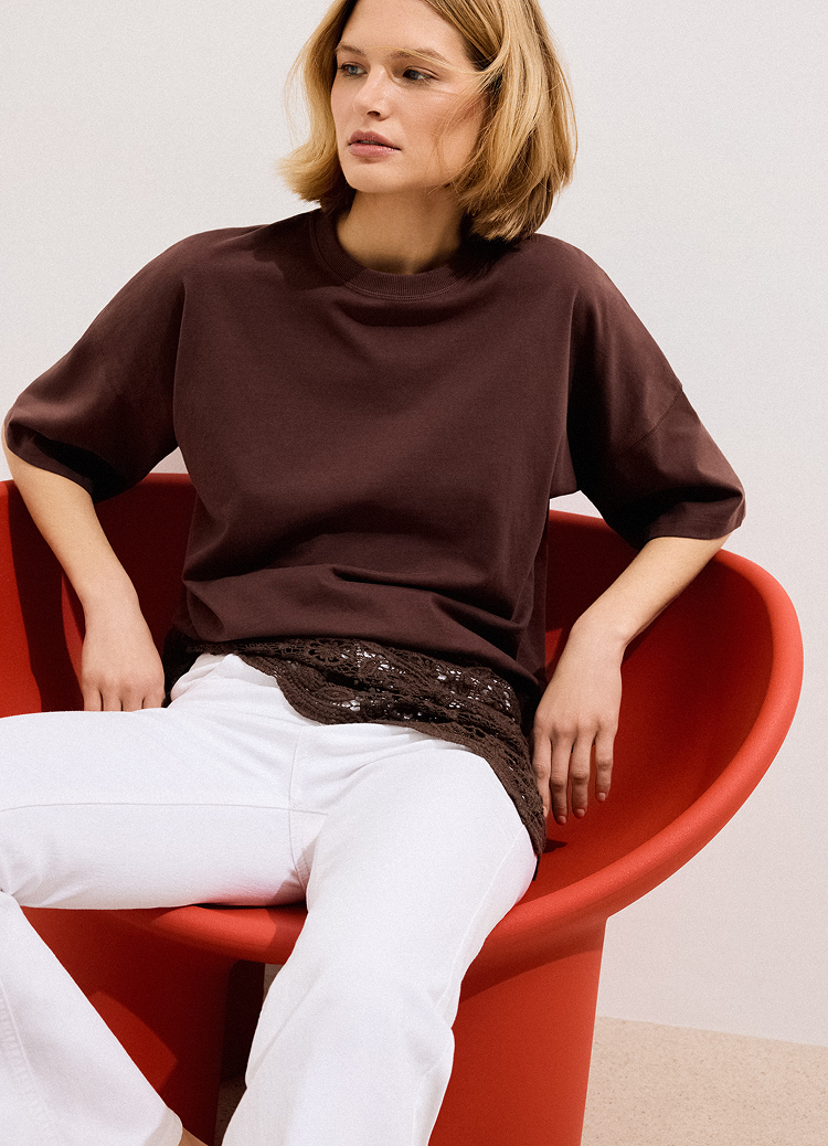 Представя дамски топ с къс ръкав, съчетан с панталон, като подчертава кройката, дължината и ежедневната елегантност.