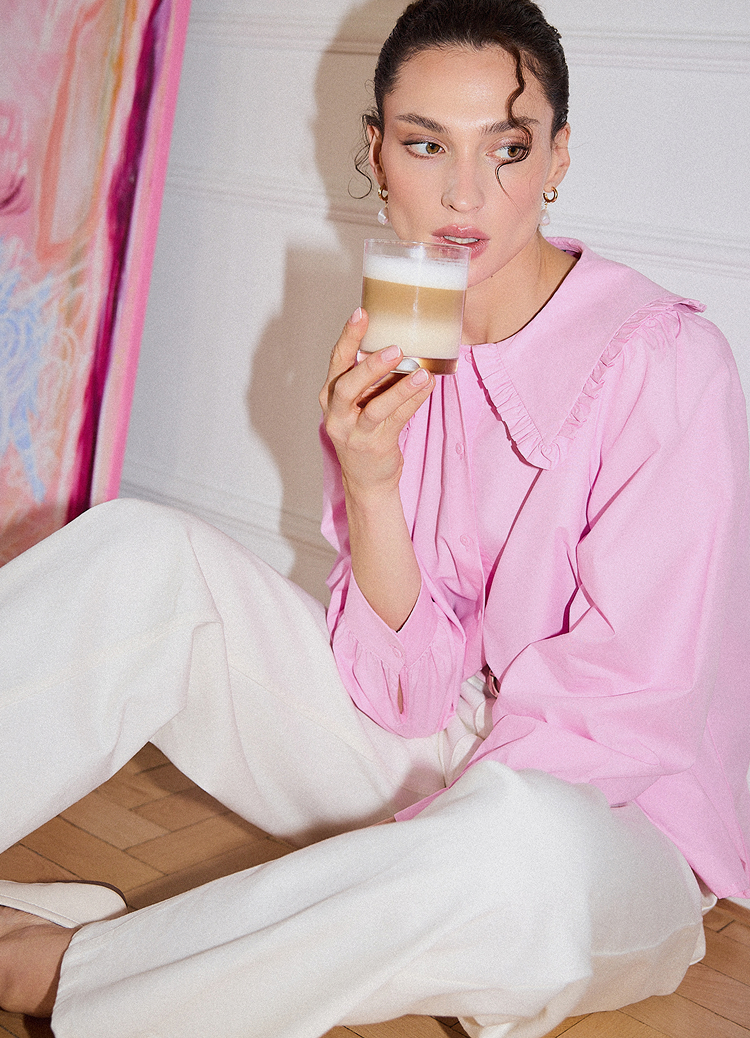 Moment de relaxare acasă, o persoană savurează o băutură caldă, sugerând confort, pauză și stare de bine.