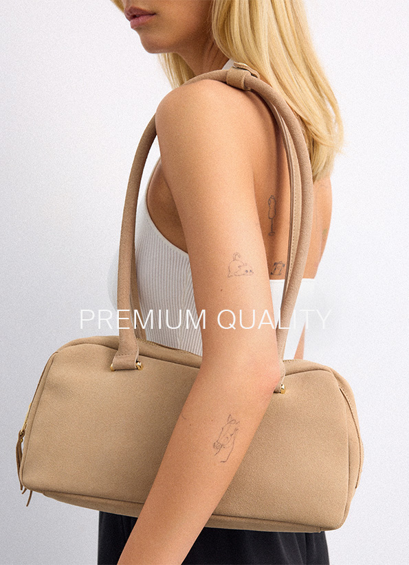 Obraz promocyjny przedstawiający wysokiej jakości torbę na ramię noszoną na ramieniu, aby zaprezentować jej rozmiar, kształt i przydatność do codziennych stylizacji.