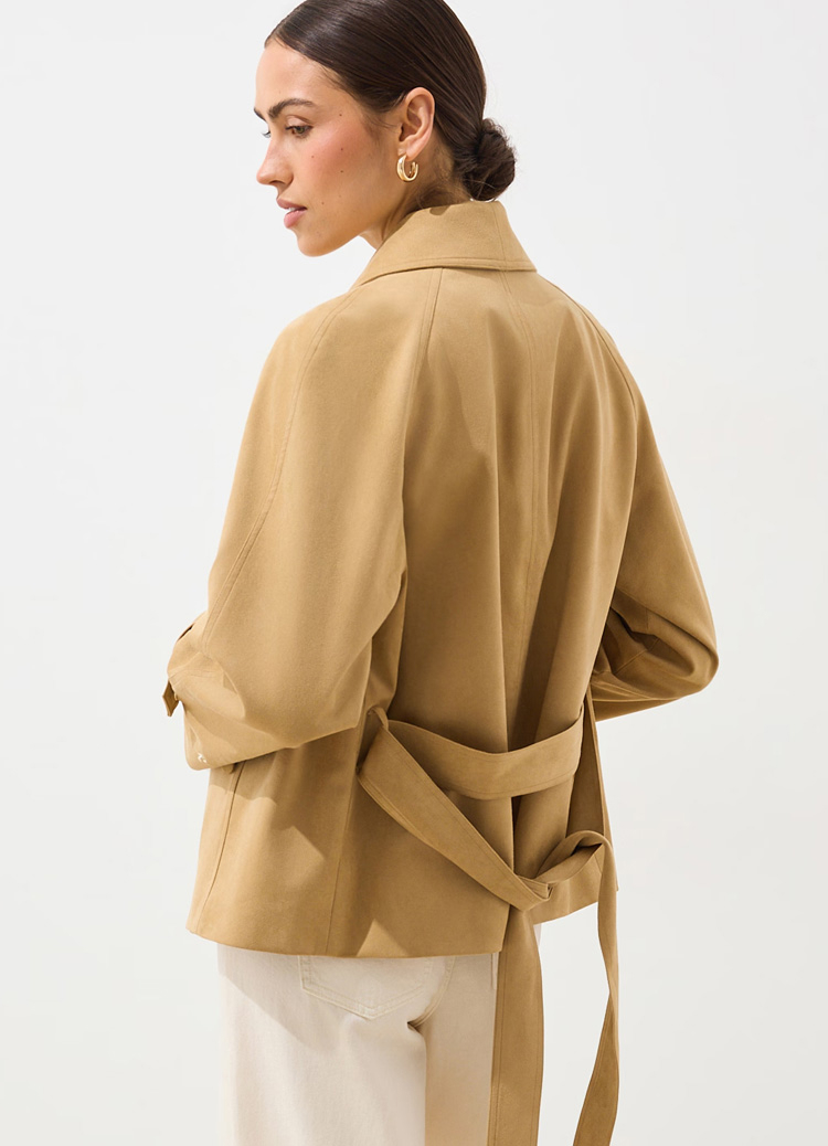 Widok z tyłu lekkiej damskiej kurtki z paskiem do wiązania, prezentujący dopasowanie, układ materiału i regulację w talii.